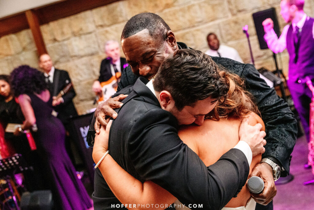 Happy couple with wedding band singer by Hoffer Photography