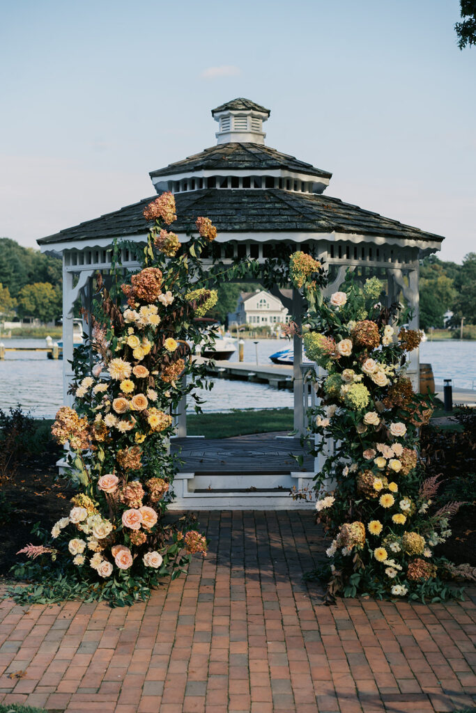 Wedding Ceremony Flower Arch positioned in front of Gazebo