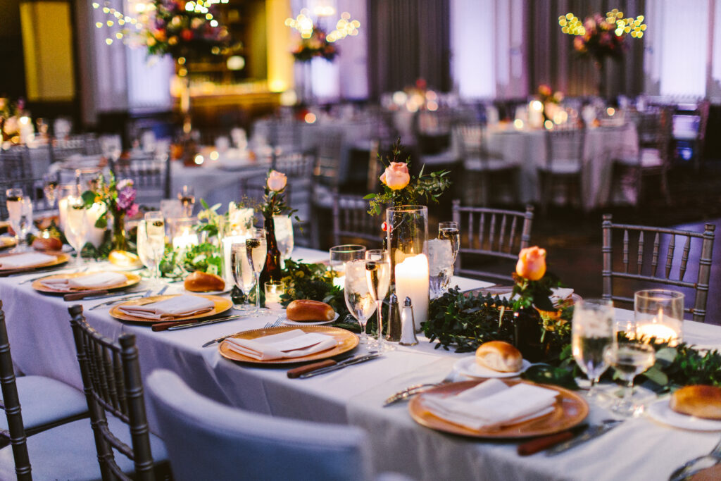 Reception dinner table decorated with flowers and candles for wedding reception at Ballroom at the Ben.